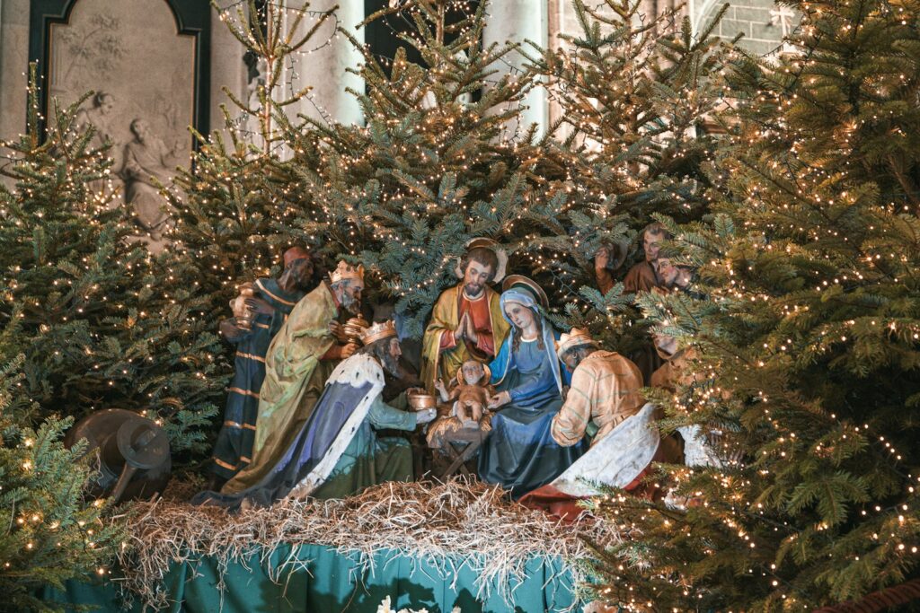 Crèche de la Nativité entourée de sapins de Noël illuminés